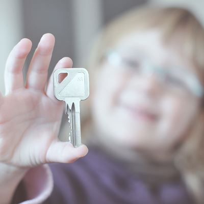 En lille pige viser glad sin husnøgle frem
