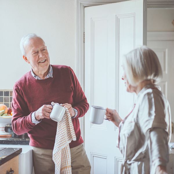 Et ældre par vasker op og taler sammen