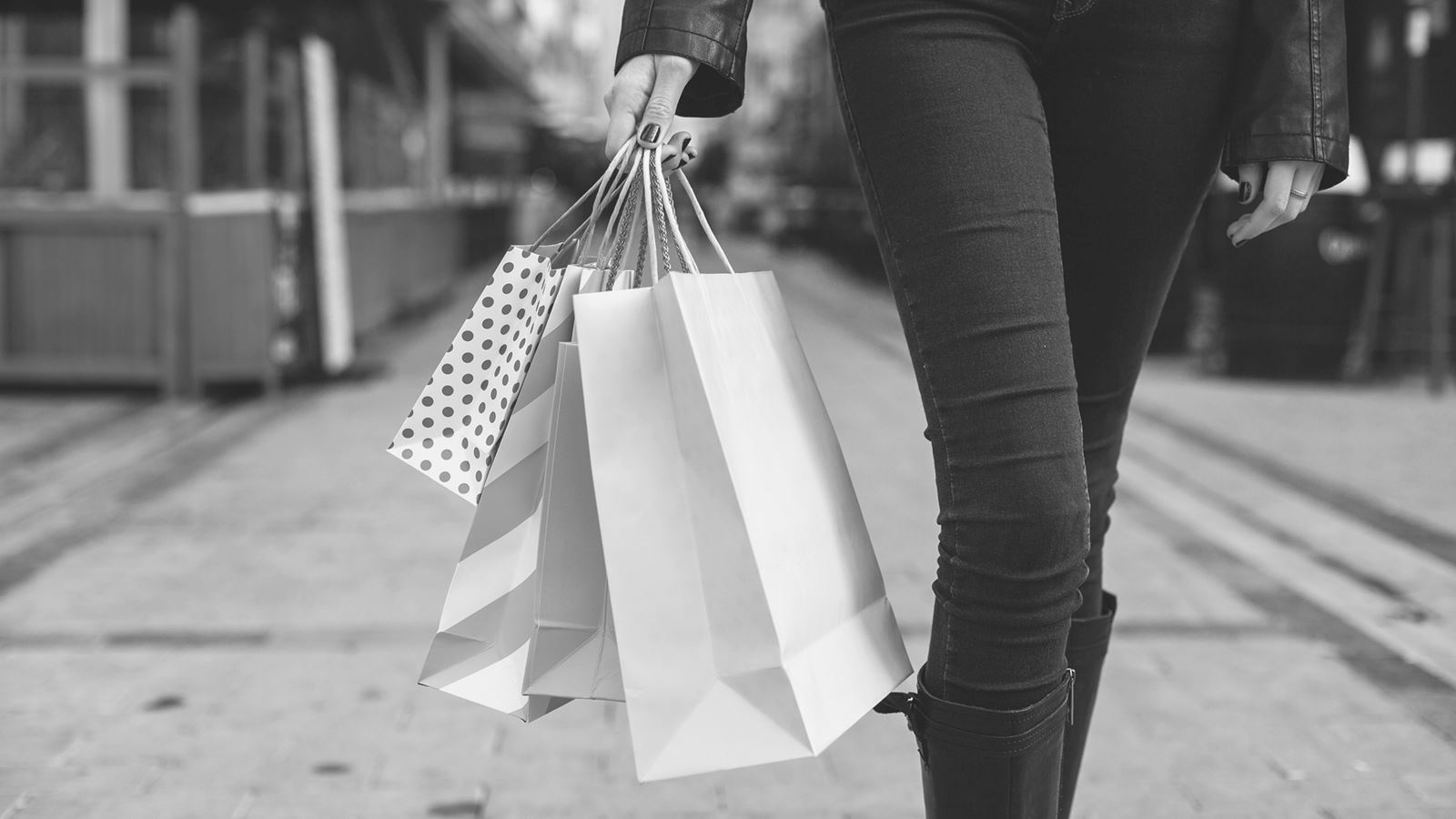 En kvinde går på gaden med shoppingposer