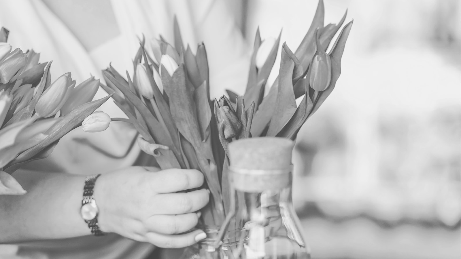En dame sætter en buket tulipaner i vase