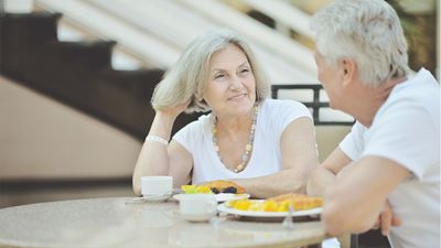 En ældre dame og mand spiser morgenmad udenfor