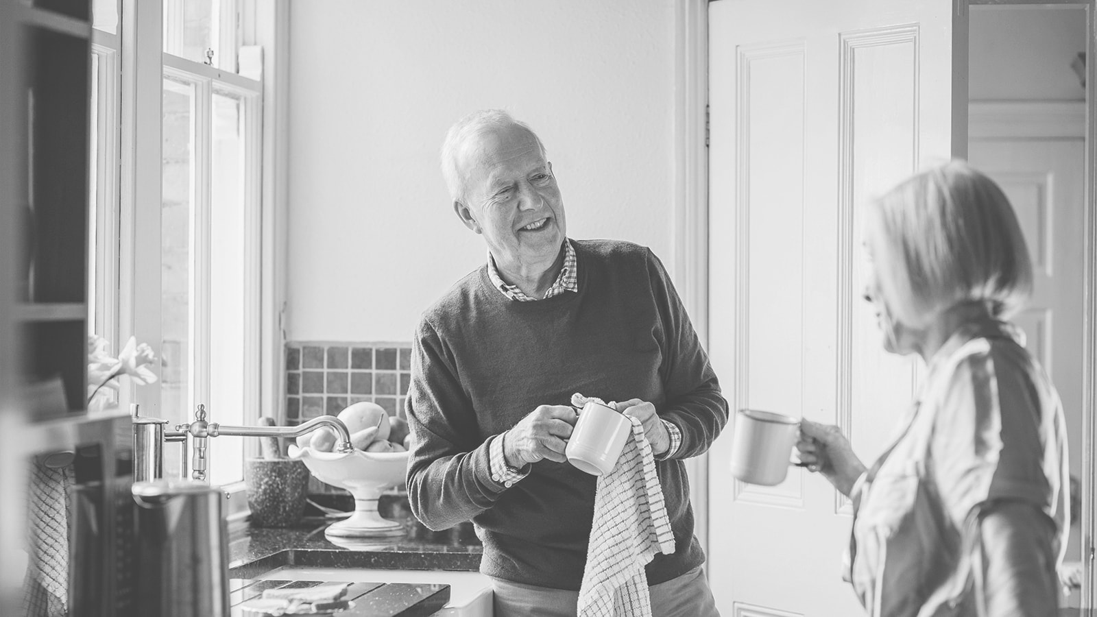 Et ældre par vasker op og taler sammen