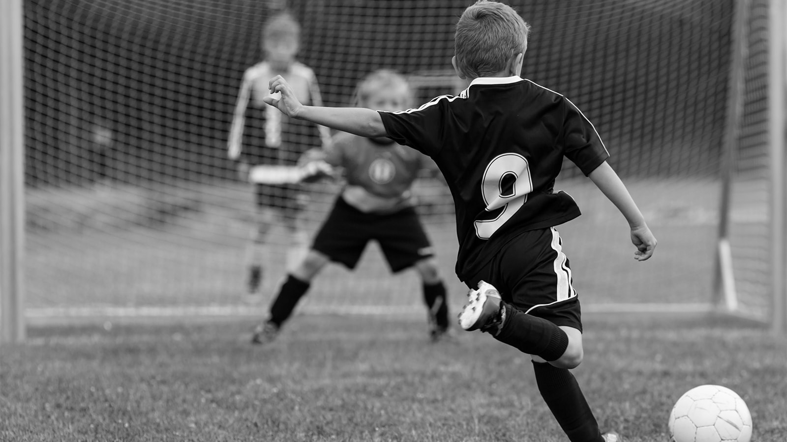 En lille dreng skal til at sparke på mål i en fodboldkamp