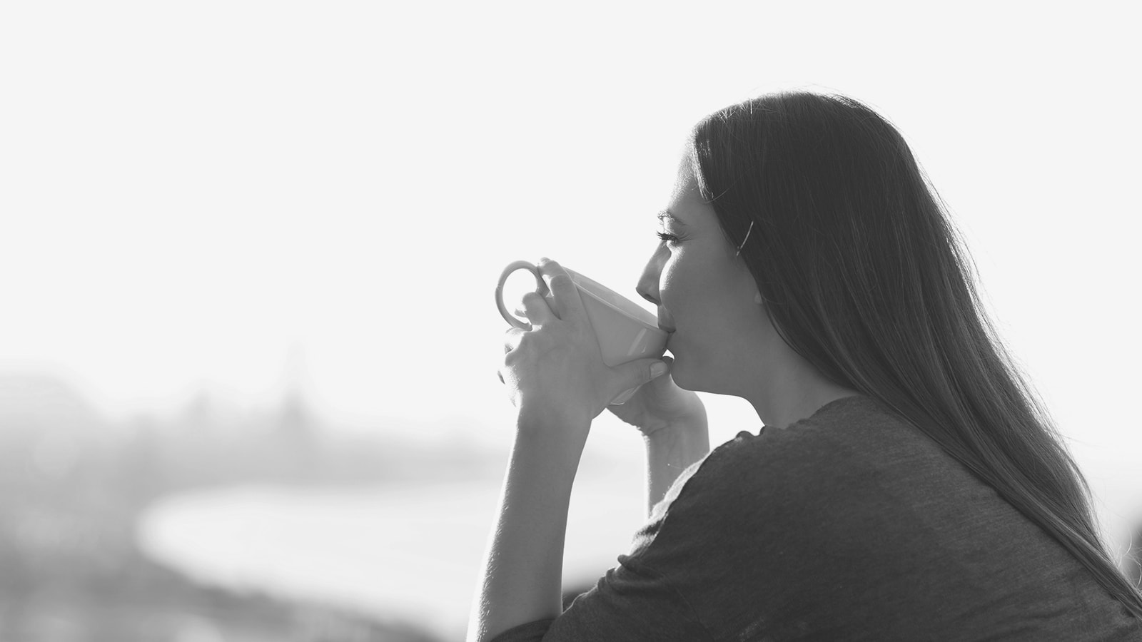 kvinde drikker kaffe på balkon
