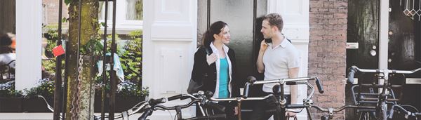 Et ungt par taler i gadedøren til en lejlighed