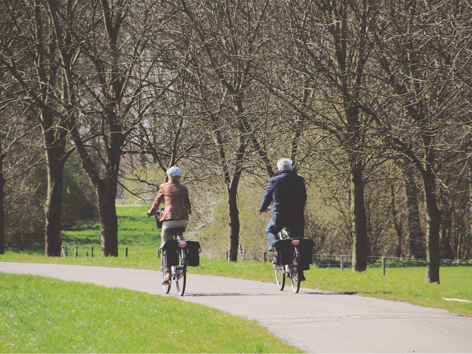 Et ældre par cykler i en park