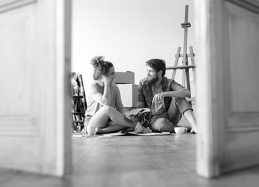 Et ungt par sidder på gulvet i flytterod