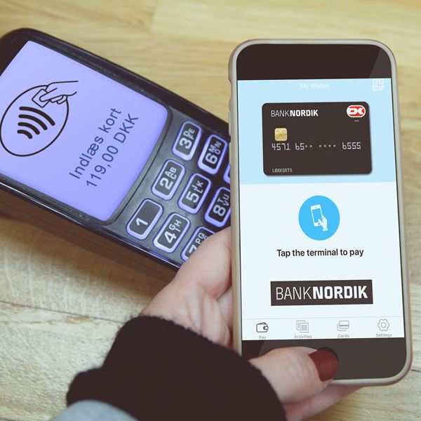 En betaling gennemføres med mobiltelefon over en terminal. 